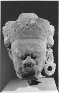Tête érodée de dvarapala paré, éclat sur la partie inférieure du visage. EFEO_CAM19037_1