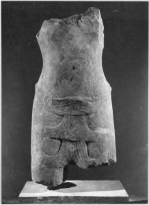 Corps masculin debout, épaules, bras et pectoraux en partie brisés, jambes brisées sous le vêtement (vu de face). EFEO_CAM19526_1