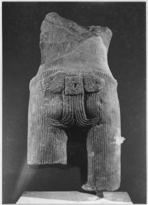 Corps masculin debout, épaules, bras et pectoraux en partie brisés, jambes brisées sous le vêtement (vu de dos). EFEO_CAM19526_2
