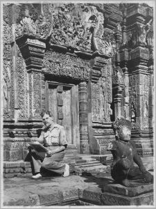 Henri Marchal assis devant la fausse porte ouest du sanctuaire central. EFEO_CAM20067